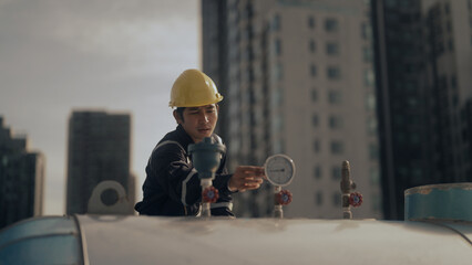 Engineer inspects pipes in a factory - obrazy, fototapety, plakaty