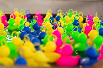 Plastic multi-colored toy ducks float in the water.