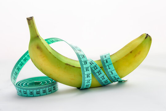 Banana with measuring tape on white background. Men penis size concept.