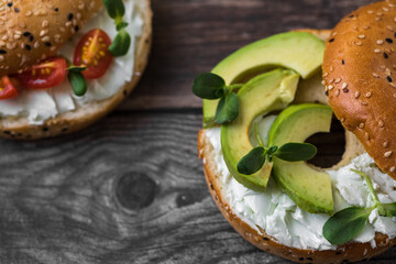 Bagel with butter and avocado on a wooden table