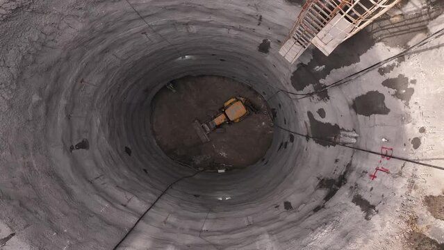 Iron climbing ladder inside the deep shaft of the subway tunnel, loader, backhoe
