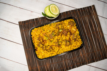 beef khichuri biryani rice pulao with cucumber and lemon slice served in dish isolated on wooden table closeup top view of bangladeshi and indian spicy lunch food