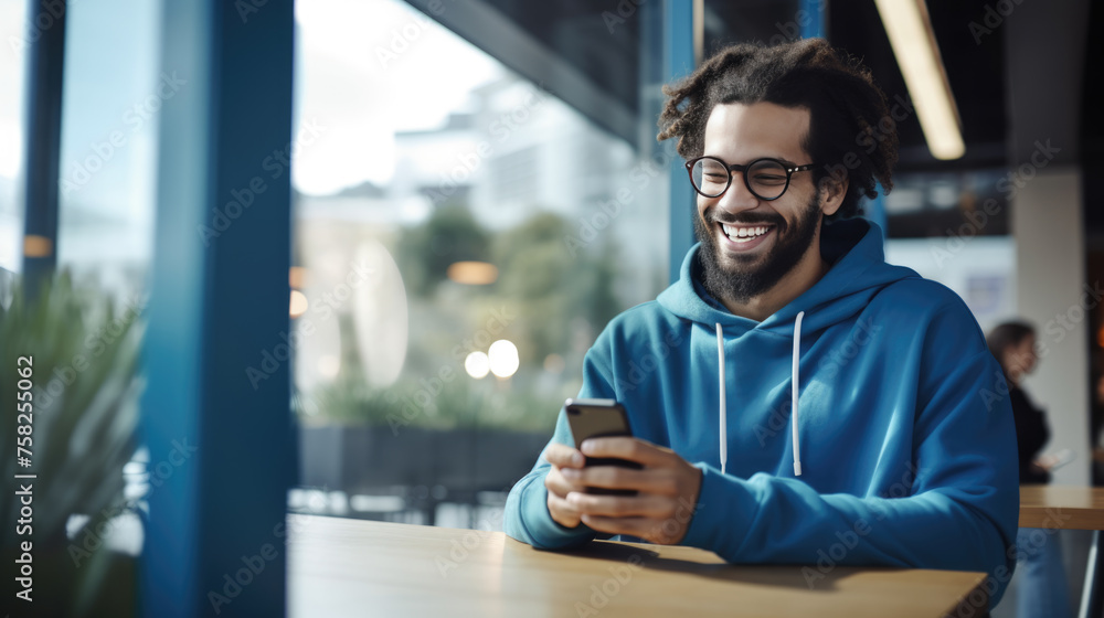 Poster Smiling man in blue clothes is using the phone