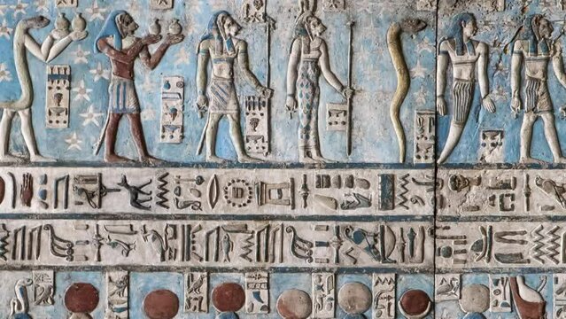 Ancient Egyptian hieroglyphs and bas-reliefs close-up in Dendera temple or Temple of Hathor. Egypt. Dendera Temple complex, one of the best-preserved temple sites from ancient Upper Egypt.