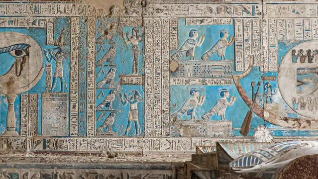 Ancient Egyptian hieroglyphs and bas-reliefs close-up in Dendera temple or Temple of Hathor. Egypt. Dendera Temple complex, one of the best-preserved temple sites from ancient Upper Egypt.