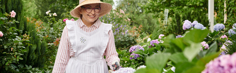 jolly mature woman with apron and gardening tools taking care of beautiful hydrangea, banner