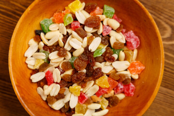 Scattered mix of dried fruits and nuts on a wooden plate