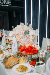 The photo depicts a table with food and flowers. 6325
