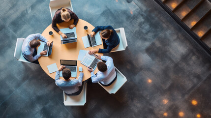 Aerial view of a professional meeting with four individuals around a round table