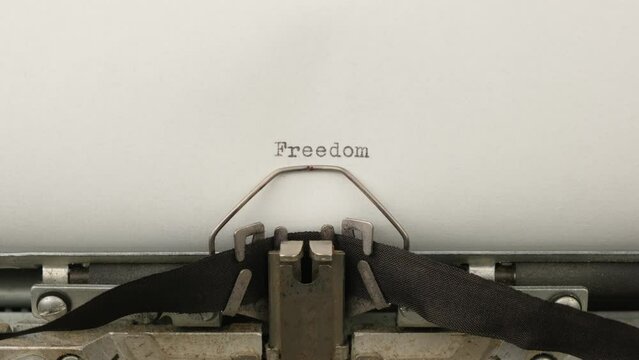 typing motivational announcement Freedom on a vintage typewriter close-up