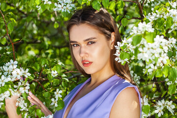 Young beautiful woman in a blooming garden