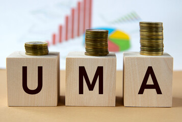 UMA - abbreviation on wooden balls on a background of coins and graphics.