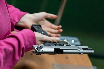 Loading a magazine to reload a gun in your hands at the shooting range