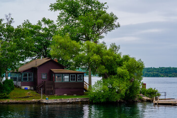 Fototapeta na wymiar Ontario lake, Canada - June 24 2018: Cruise boat and resorts with deck in Ontario Lake