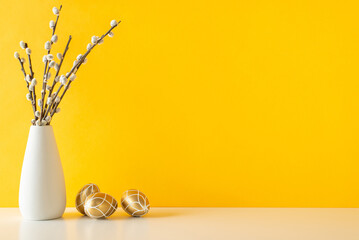 Easter-themed modern kitchen look, presenting side view table with golden eggs, and a vase of pussy-willow, set against a dynamic yellow wall, space for text or ads - obrazy, fototapety, plakaty