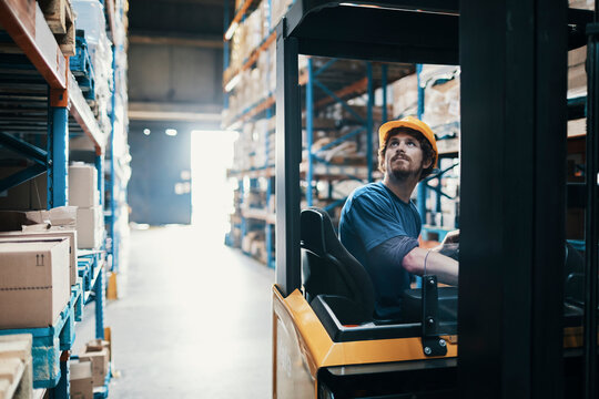 Male forklift operator working in warehouse - Powered by Adobe