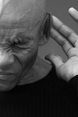 deaf man suffering from deafness and hearing loss on grey background with people stock photo	