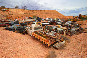 Junkyard of rusty abandoned vintage cars in the desert of the Australian outback of the red center...