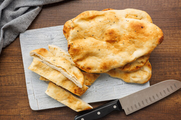 Freshly Baked Naan Bread on cutting board on wooden table