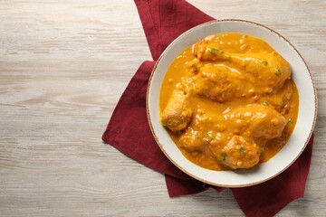 Tasty chicken curry on wooden table, top view. Space for text