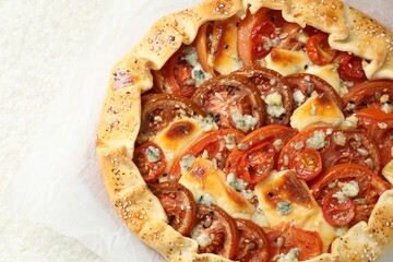 Tasty galette with tomato and cheese (Caprese galette) on light textured table, top view