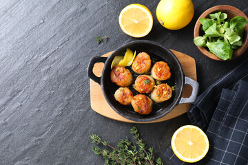 Delicious fried scallops and ingredients on dark gray textured table, flat lay. Space for text