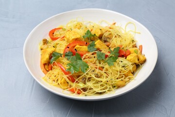Stir-fry. Delicious cooked noodles with chicken and vegetables in bowl on gray table, closeup