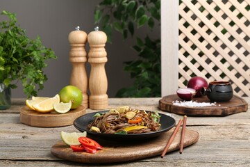 Stir-fry. Tasty noodles with meat and vegetables served on wooden table