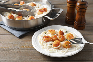 Delicious scallop pasta served on wooden table