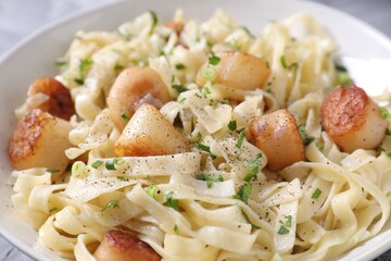 Delicious scallop pasta with spices in bowl, closeup