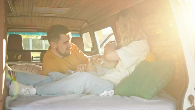 A tender family moment inside a vintage van, with a baby wearing a knitted sweater, surrounded by a cozy wooden interior.
