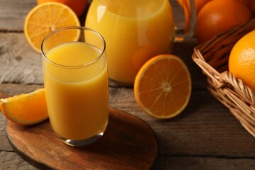 Tasty fresh oranges and juice on wooden table, closeup