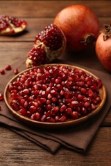 Ripe juicy pomegranates and grains on wooden table