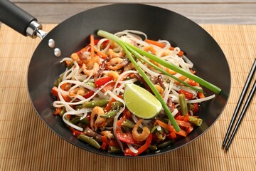 Shrimp stir fry with noodles and vegetables in wok on table - 758323098