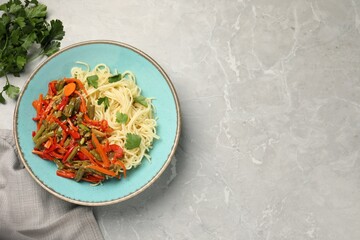 Vegetarian meal. Tasty pasta with vegetables on light grey marble table, top view. Space for text