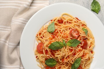 Vegetarian meal. Tasty pasta with fresh tomatoes and basil on light grey table, top view
