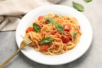Vegetarian meal. Tasty pasta with fresh tomatoes and basil on light grey table