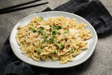 Vegetarian meal. Tasty pasta with fresh vegetables and cheese on grey table
