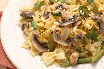 Vegetarian pasta with mushrooms, parsley, string beans and cheese on white plate, closeup