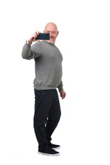 front view of a man taking a self-portrait with smartphone on white background