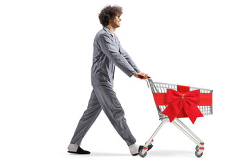 Young man in pajamas walking with a shopping cart tied with a red ribbon