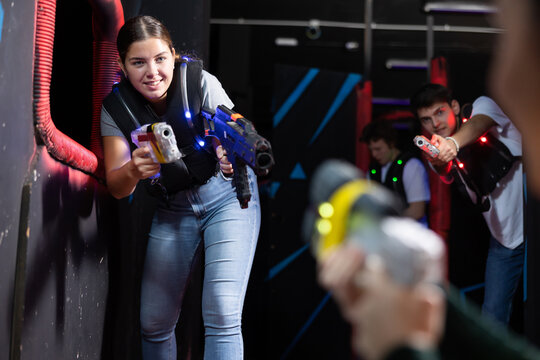 Girl running and dodging while playing lasertag