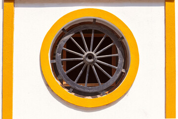 Round porthole window with a wheel in the wall of a house in Cadiz. - 758345065