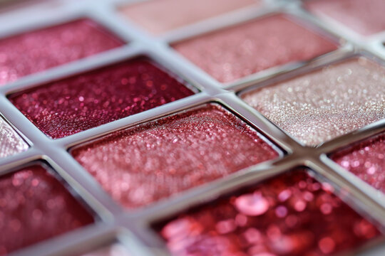 A close-up of pearlescent shimmery palette of pink eyeshadows for creating eye makeup