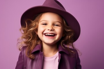Portrait of a smiling little girl in a purple coat and hat