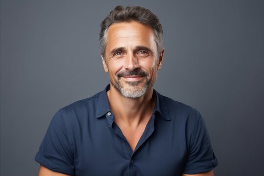 Portrait of handsome mature man in casual t-shirt against grey background