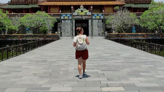 Young woman entering the beautiful Imperial City of Hue, Vietnam. Woman traveling alone in Vietnam. Young woman enjoying the beautiful city of Hue, Vietnam