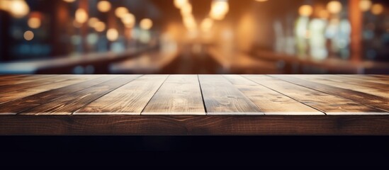An empty hardwood table on a dark wood floor, with a blurry background of a restaurant. Automotive lighting tints the scene with shades of darkness - obrazy, fototapety, plakaty
