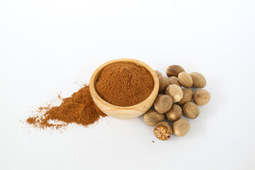 raw material of nutmeg seeds and powder in a wooden bowl