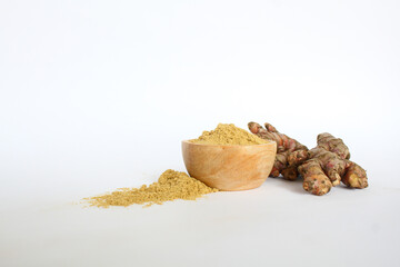 raw ginger material and powder in a wooden bowl